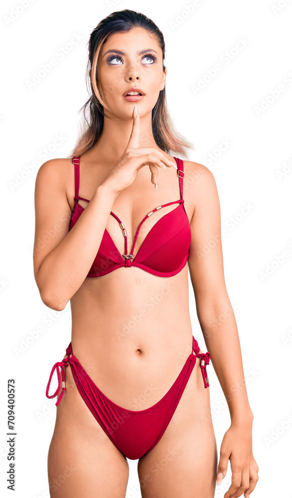 Fototapeta premium Young beautiful woman wearing bikini thinking concentrated about doubt with finger on chin and looking up wondering