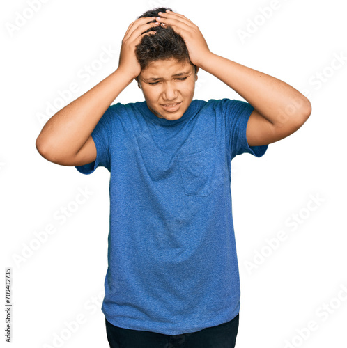 Teenager hispanic boy wearing casual clothes suffering from headache desperate and stressed because pain and migraine. hands on head.