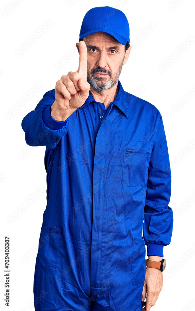 Middle age handsome man wearing mechanic uniform pointing with finger up and angry expression, showing no gesture