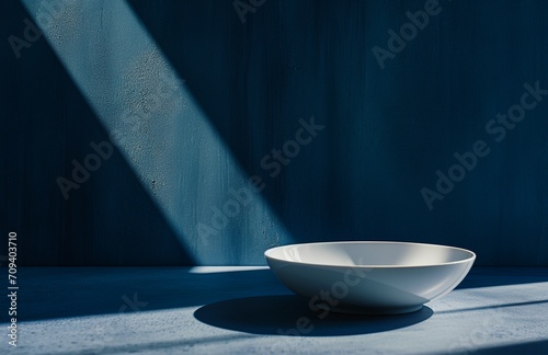 a white bowl sitting on top of a table next to a blue wall