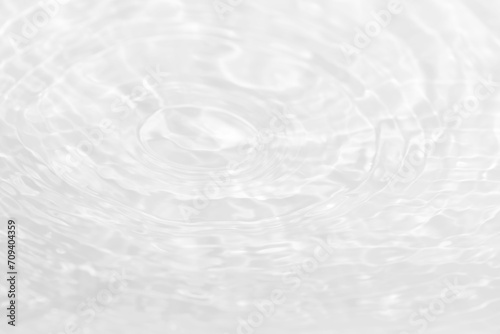 White water with ripples on the surface. Defocus blurred transparent white colored clear calm water surface texture with splashes and bubbles. Water waves with shining pattern texture background.