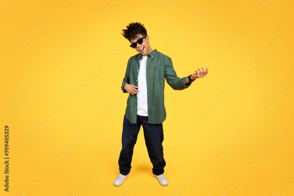 Stylish young black guy wearing sunglasses playing imaginary guitar Stylish young black guy wearing sunglasses playing imaginary guitar