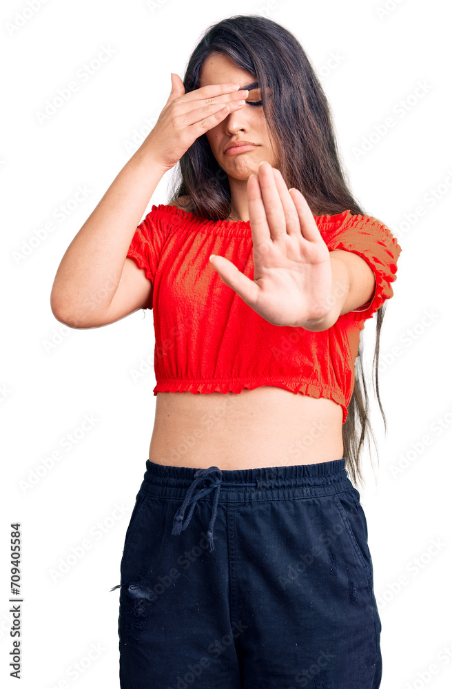 Brunette teenager girl wearing casual clothes covering eyes with hands and doing stop gesture with sad and fear expression. embarrassed and negative concept.