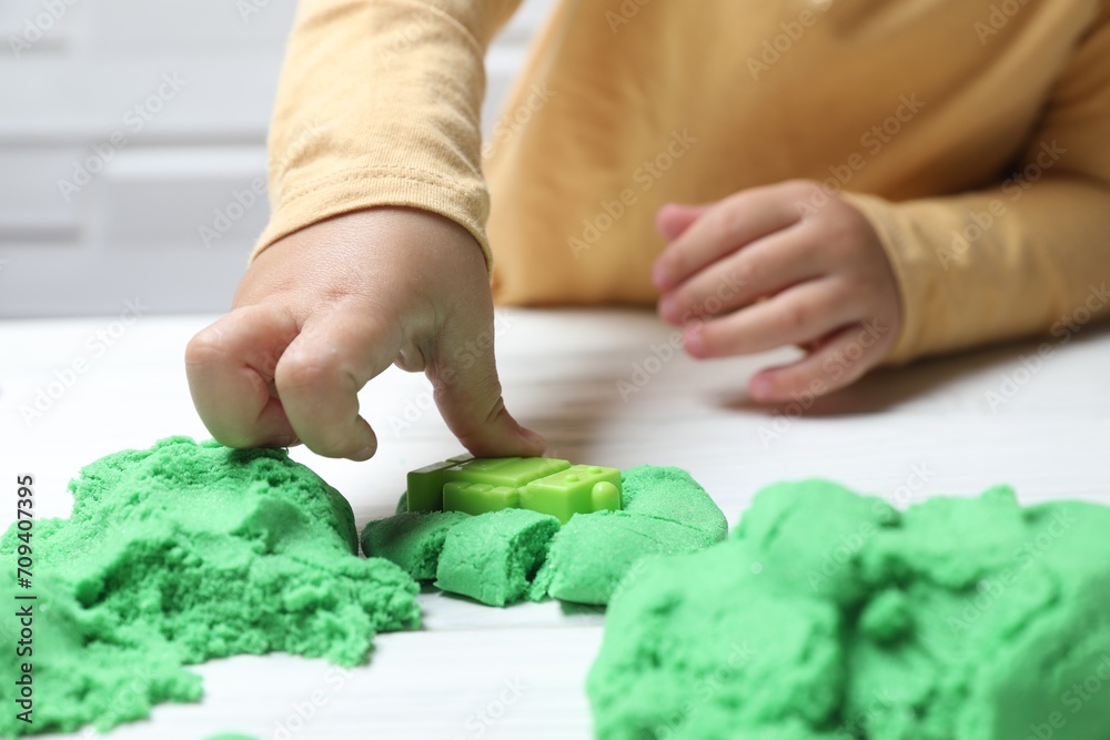 Little child playing with kinetic sand at white table, closeup Little child playing with kinetic sand at white table, closeup
