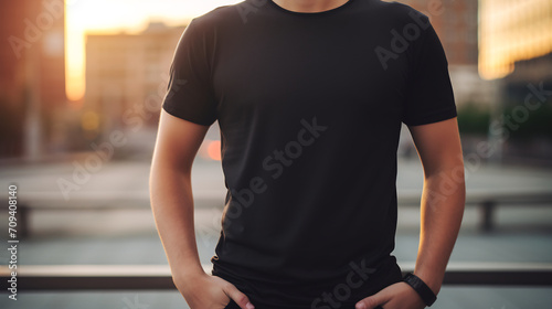 Unrecognizable Man in Black T-Shirt Standing Against City Skyline at Sunset, Urban Apparel Mockup photo