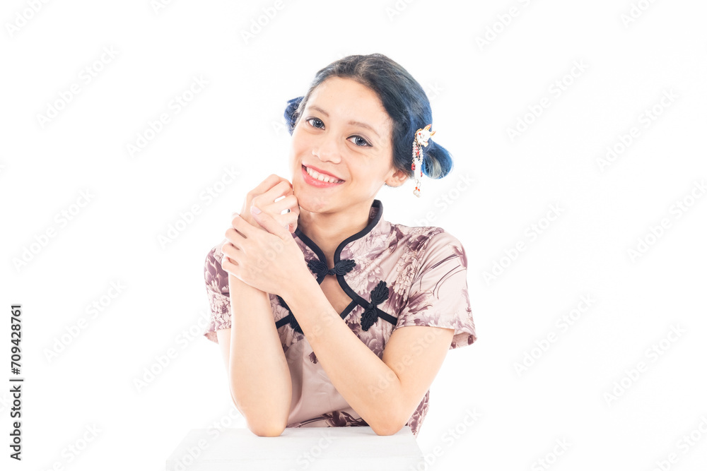 Portrait of an attractive Asian Chinese female wearing cheongsam or qipao isolated on white background for Chinese New Year concept Portrait of an attractive Asian Chinese female wearing cheongsam or qipao isolated on white background for Chinese New Year concept