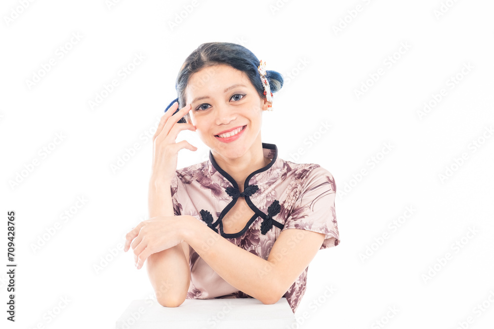 Portrait of an attractive Asian Chinese female wearing cheongsam or qipao isolated on white background for Chinese New Year concept Portrait of an attractive Asian Chinese female wearing cheongsam or qipao isolated on white background for Chinese New Year concept