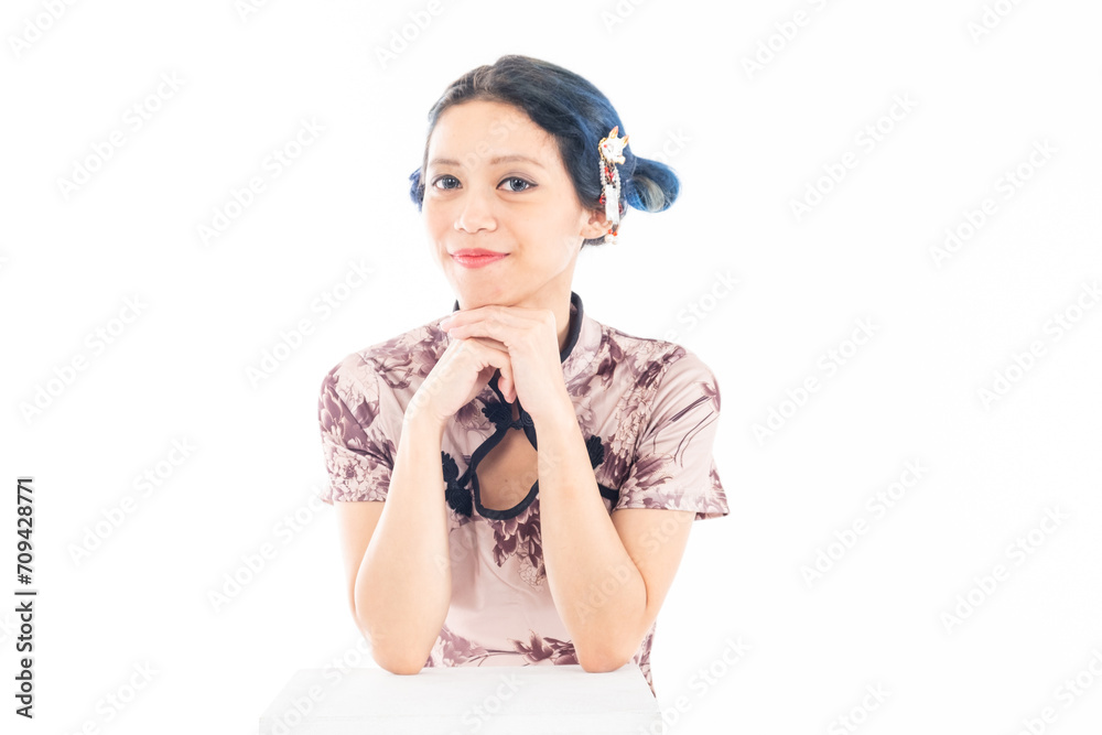 Portrait of an attractive Asian Chinese female wearing cheongsam or qipao isolated on white background for Chinese New Year concept Portrait of an attractive Asian Chinese female wearing cheongsam or qipao isolated on white background for Chinese New Year concept