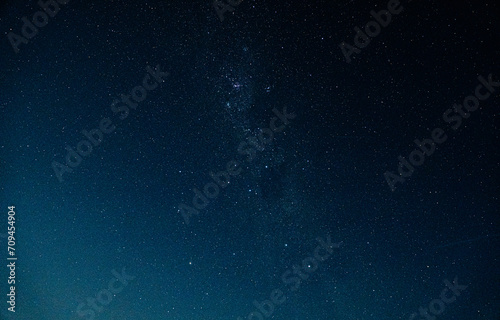 Starry night sky filled with luminous stars, illuminating the dark blue expanse. © Emilia