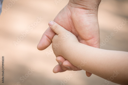 Little kid holding family member mother hand as a together family © natrocfort