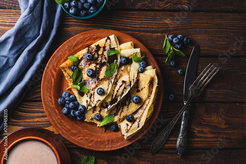 Pancakes with blueberries, chocolate sauce and mint photo