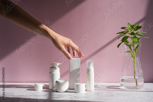 Hand is touching skincare set for cosmetic and beauty concept. photo