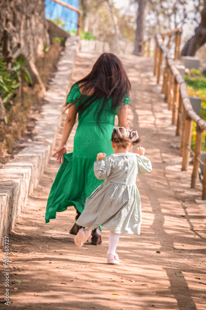 Family members holding hands and walking backwards in a park together family Family members holding hands and walking backwards in a park together family