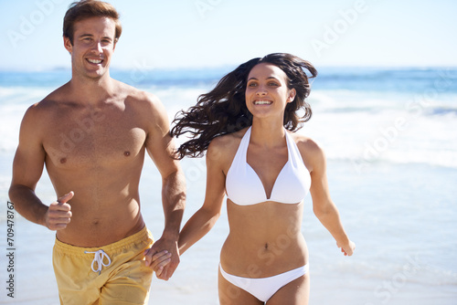 Holding hands, run and happy couple on beach for holiday adventure together on tropical island with waves. Love, man and woman on fun ocean vacation with waves, romance and smile on travel in Hawaii.