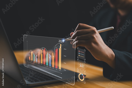 Businessman investor analyzes profitability of working companies with digital augmented reality graphics, positive indicators in 2024, businessman calculates financial data for long-term investments. photo