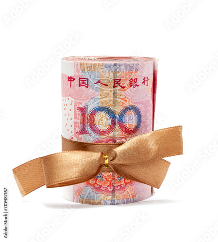 Roll of chinese yuan banknotes tied with gold ribbon isolated on white