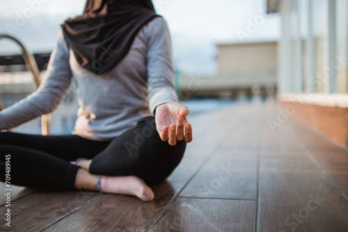 close up of a woman's hand pose meditating sitting by the pool