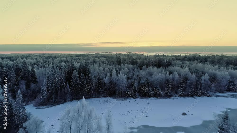 Cold winter landscape and forest with glowing sunset sky, aerial view Cold winter landscape and forest with glowing sunset sky, aerial view