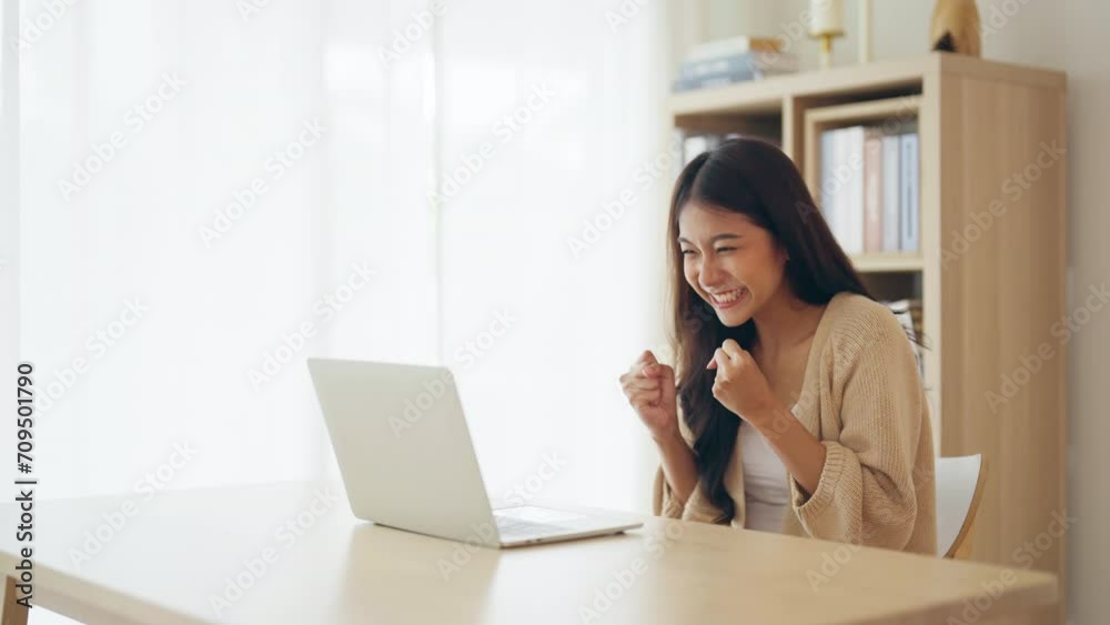Funny euphoric young asian woman celebrating winning or getting ecommerce shopping offer on computer laptop. Excited happy girl winner looking at notebook celebrating success Funny euphoric young asian woman celebrating winning or getting ecommerce shopping offer on computer laptop. Excited happy girl winner looking at notebook celebrating success