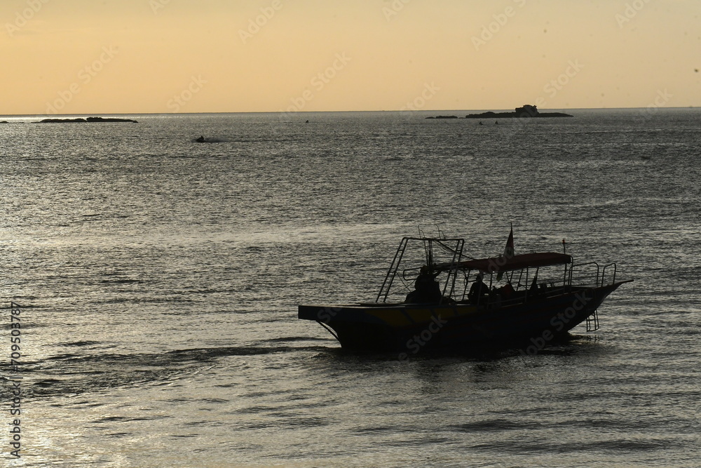 a boat that is on the water in the sunset setting