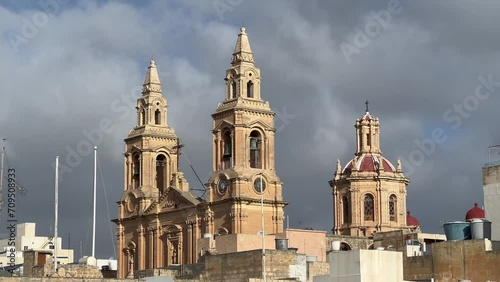 Our Lady of the Sacred Heart Parish Church, Sliema, Malta: 4K shot showcases Neo-Gothic architecture against dramatic clouds. A good representation of Malta's architectural beauty. photo