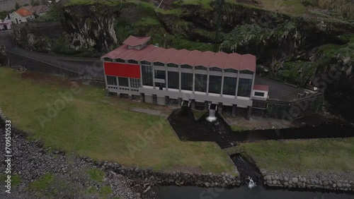 Aerial view of an hydroelectric power plant  on the river mouth, drone moving forward in direction of the power plant and camera tilting down. Porto Moniz Madeira island.