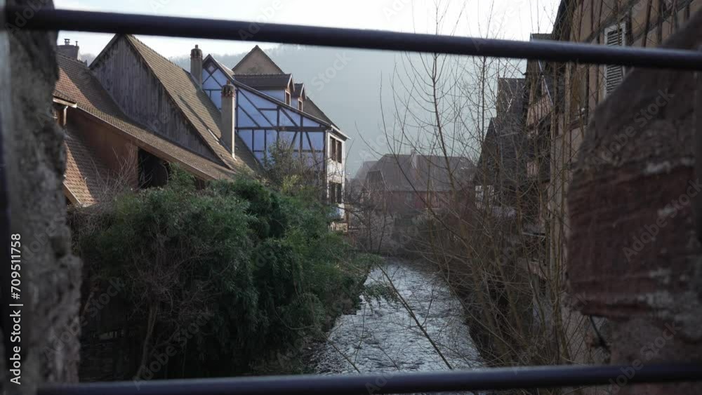 Scenic wide shot of half-timbered houses near the Weiss river stream flowing through medieval town in France, Kaysersberg. Scenic wide shot of half-timbered houses near the Weiss river stream flowing through medieval town in France, Kaysersberg.