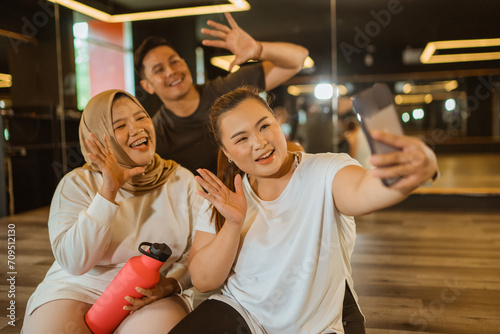 sporty people taking selfie together after exercise in the gym