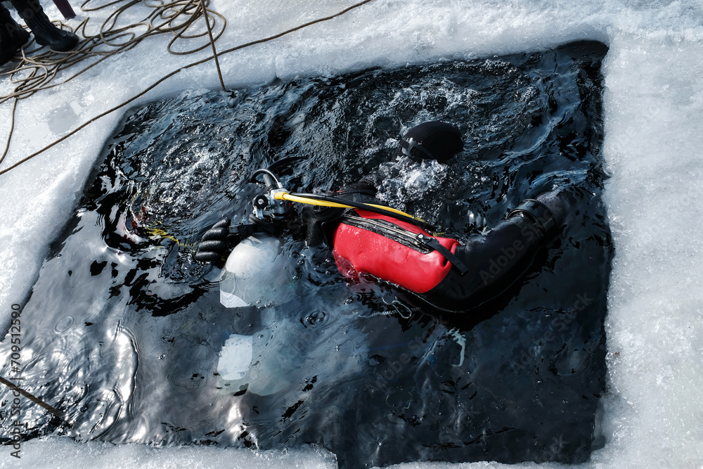 Obraz premium Two divers immersing into an ice hole