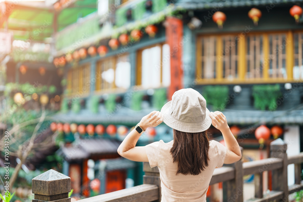 woman traveler visiting in Taiwan, Tourist with hat sightseeing in Jiufen Old Street village with Tea House background. landmark and popular attractions near Taipei city . Travel and Vacation concept - obrazy, fototapety, plakaty 
