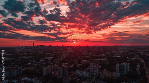  the sun is setting over a city with tall buildings in the foreground and a red sky in the background.
