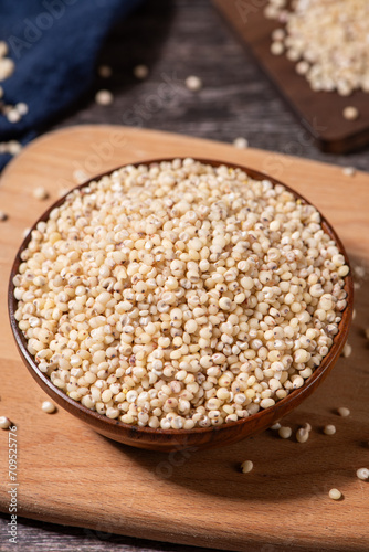 Sorghum seeds in plate on wooden table. Whole seeds of Sorghum Moench