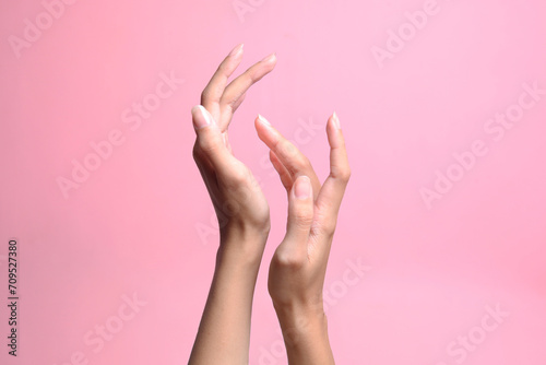 Touching hands of woman on pink pastel background. Femininity, body, skin and beauty. © Queenmoonlite Studio