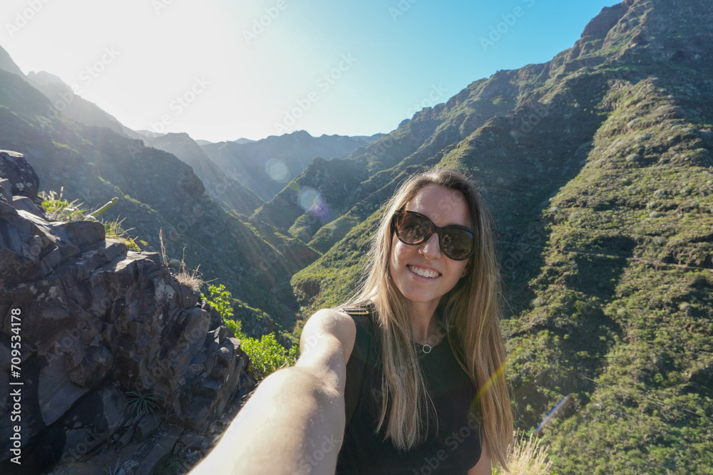 Naklejka premium Young woman in Morning Adventure Selfie Capturing the Serenity of a Mountainous Landscape