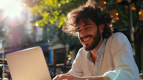 Smiling man holding credit card and using laptop photo