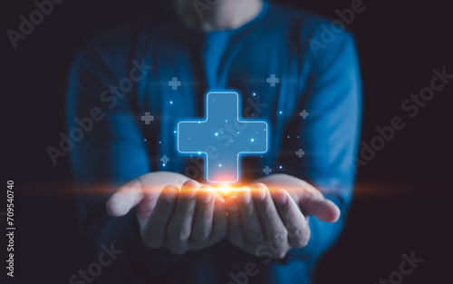 Healthcare insurance and medicine concept. Businessman holding virtual blue plus sign for positive thinking mindset or healthcare insurance symbol, Mental health care, mental rejuvenation.