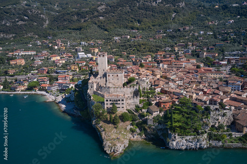 Malcesine is a small town on the shore of Lake Garda in Verona province, Italy. Malcesine - The panorama of promenade over the Lago di Garda lake with the town and castle in the background