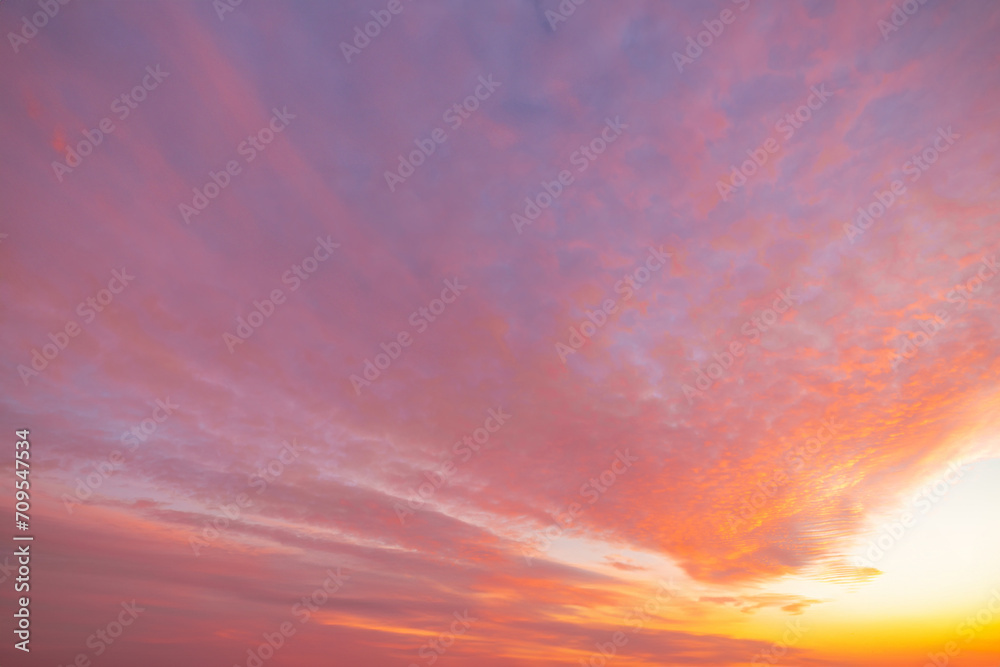 Fototapeta premium A beautiful sky tinted by the sun leaving vibrant shades of gold, pink, blue and multicolored. Clouds in the twilight evening and morning sky. Cloudy sky background in the evening and during the day.