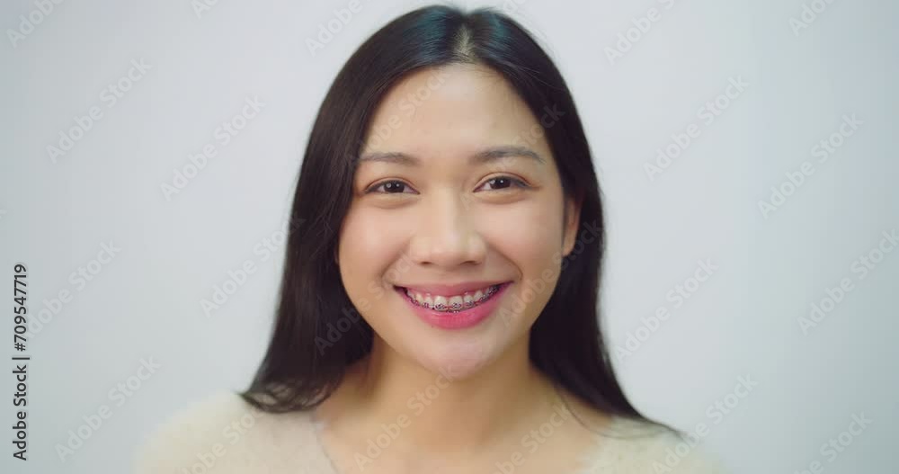 Happy beautiful asian girl with braces. She looking to camera with attractive smiling at white background. Happy beautiful asian girl with braces. She looking to camera with attractive smiling at white background.