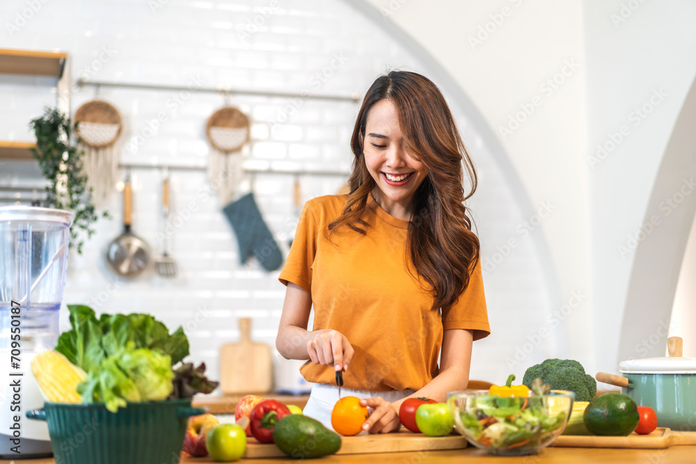 Portrait of beauty body slim healthy asian woman eating vegan food healthy with fresh vegetable salad in kitchen at home.diet, vegetarian, fruit, wellness, health, green food.Fitness and healthy food