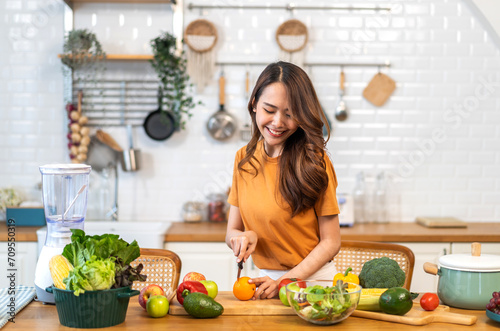 Portrait of beauty body slim healthy asian woman eating vegan food healthy with fresh vegetable salad in kitchen at home.diet, vegetarian, fruit, wellness, health, green food.Fitness and healthy food