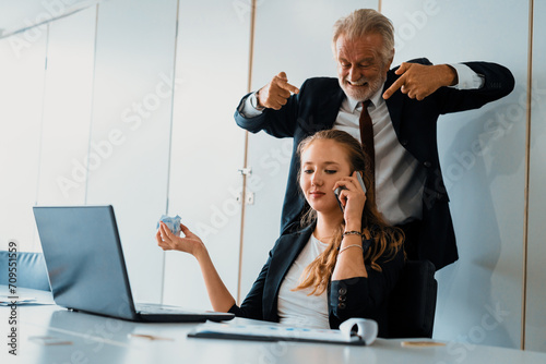 Businessman boss feels angry and mad at bad misbehaving businesswoman employee who ignores the work tasks at the workplace. Firing workers and human resources management problem concept. uds photo