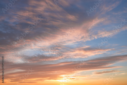 A beautiful sky tinted by the sun leaving vibrant shades of gold, pink, blue and multicolored. Clouds in the twilight evening and morning sky. Cloudy sky background in the evening and during the day. © Volodymyr