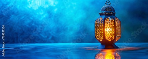 Traditional Ramadan Lanterns ,Ornate Arabic lantern reflecting on a blue surface, casting a warm, intricate glow that contrasts with the Cool ramadan background, Festive Atmosphere Ornamental Arabic photo