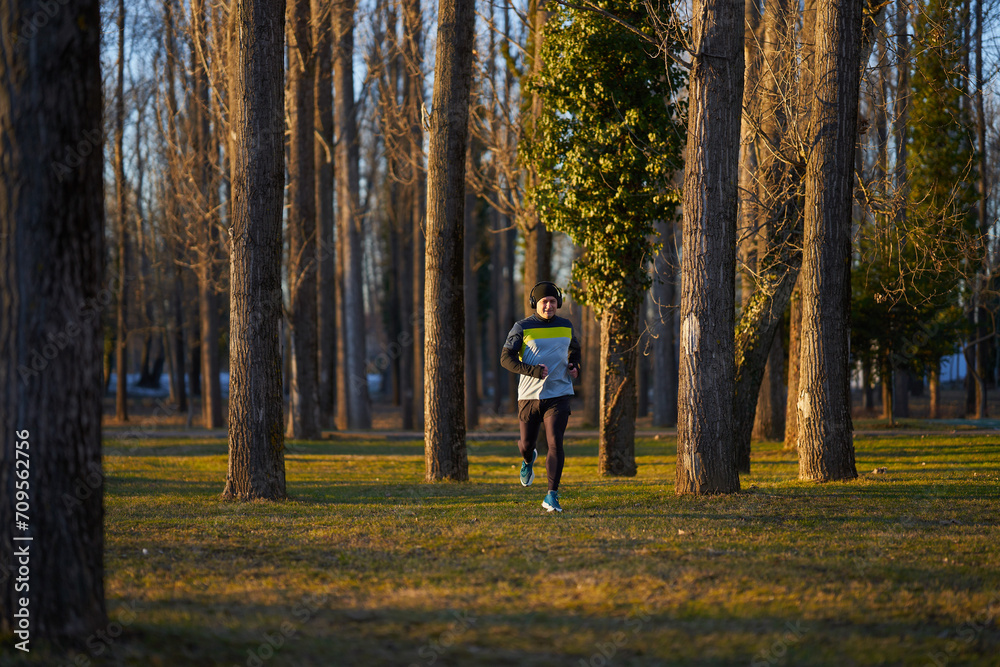 Fototapeta premium Mature man running in the park with headphones