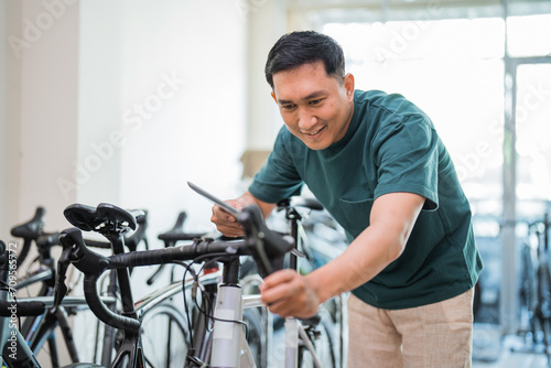 young man holding a pad while trying out a bicycle grip handlebar at a bicycle shop