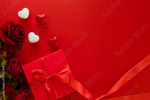 Valentine's Day decorations concept. Top view photo of gift boxes with rose and heart on isolated pastel red background with copyspace