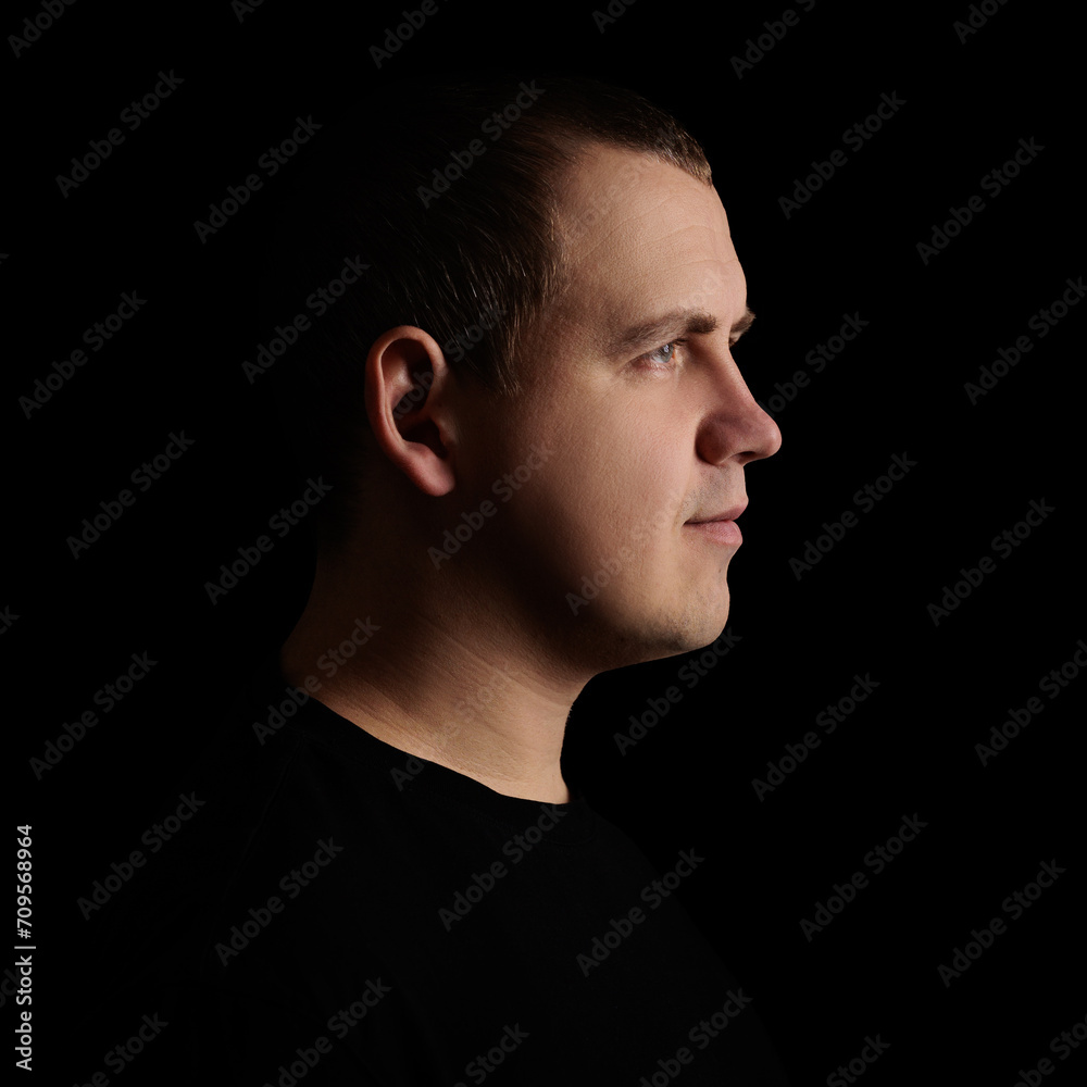 Side view portrait of happy man on dark background Side view portrait of happy man on dark background