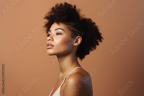 Beautiful african american woman with afro hairstyle on brown background
