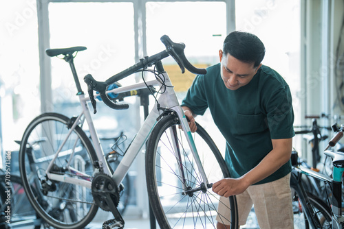 asian male employee assembles a new bike while working at a bike shop